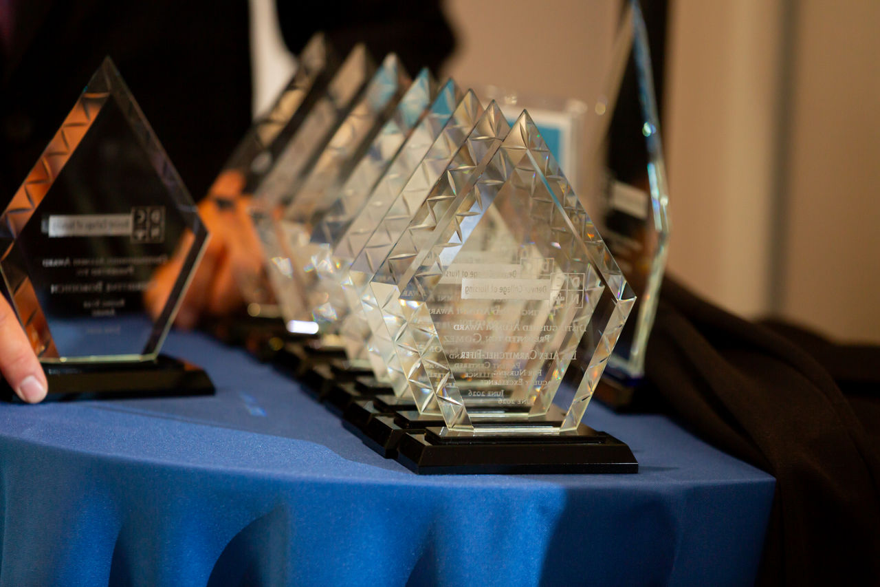 Row of Glass Awards on Blue Tablecloth